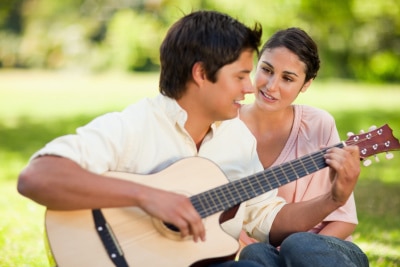 一个男人在给他女朋友弹吉他